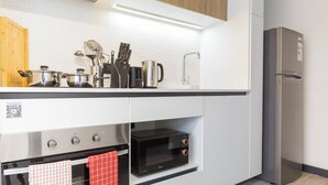 Eine moderne Küche mit Edelstahlgeräten, darunter eine Mikrowelle, ein Backofen und ein Kühlschrank.