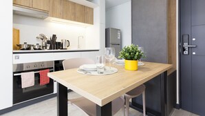 Eine moderne Küche mit Einbaugeräten, einem Esstisch mit Stühlen und einem Blumentopf.