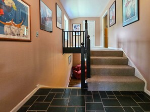 A staircase with a black railing leading to a landing, surrounded by walls with framed pictures. - Shenandoah Sky House - walk to Lake Laura trail! + fire pit (Basye)