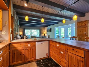 A kitchen with wooden cabinets, a dishwasher, and pendant lighting. - Shenandoah Sky House - walk to Lake Laura trail! + fire pit (Basye)
