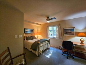 A bedroom with a bed, desk, chair, ceiling fan, window with curtains, and a picture on the wall. - Shenandoah Sky House - walk to Lake Laura trail! + fire pit (Basye)