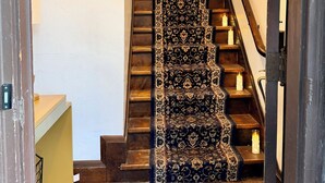 Una escalera con alfombra estampada y velas en cada peldaño.