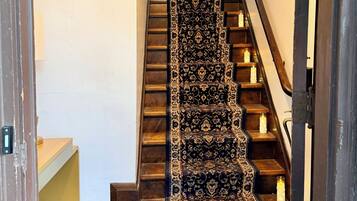 A staircase with a patterned carpet and candles on each step.
