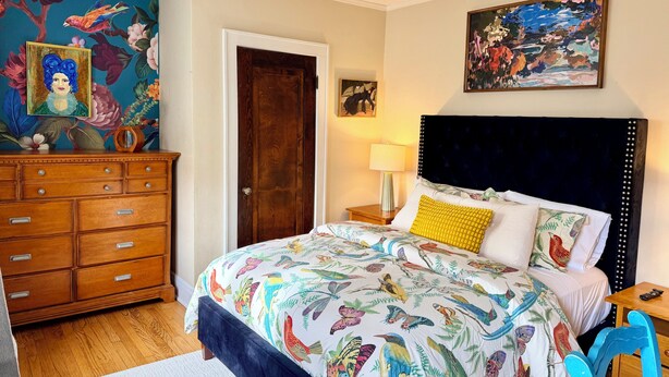 Un dormitorio con cama, cómoda y una puerta.