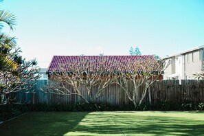 A residential building with a red-tiled roof, a wooden fence, and a well-maintained lawn. - Oceans 1, Beach Views, 3-Min Walk to Birubi Beach (Anna Bay)