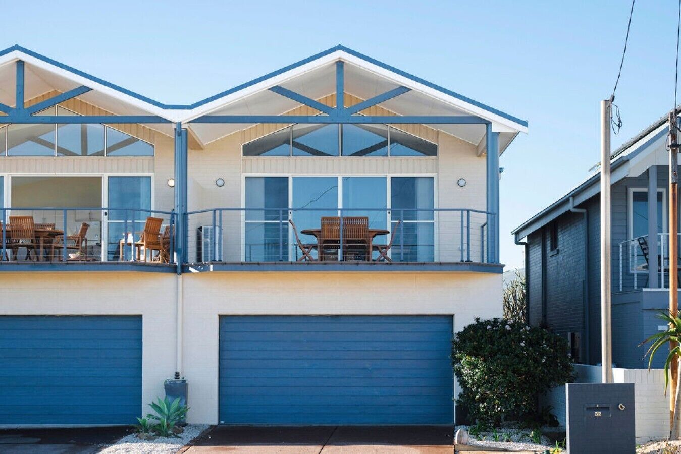 A two-story house with a balcony, large windows, and a garage.