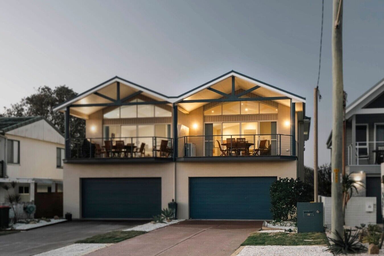 A two-story house with a balcony, a garage, and a well-maintained lawn.