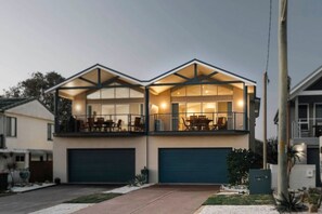 A two-story house with a balcony, a garage, and a well-maintained lawn. - Oceans 2, Ocean Views, 3-Min Walk to Birubi Beach (Anna Bay)