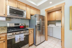 A modern kitchen with stainless steel appliances, wooden cabinets, and a gas stove. - 4 Virginia Rail - Dog-Friendly Sunriver Home with A/C, Hot Tub & SHARC Passes (Sunriver)