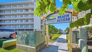 Un edificio residenziale a più piani con un cartello che indica l'accesso alla spiaggia.