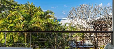 Ein Balkon mit Blick auf ein Gebäude und einen Baum.