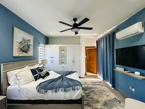A bedroom with a bed, a ceiling fan, a TV, and a wardrobe. - Sosua Ocean Village Luxury Villa: 3BR/3.5BA Pool Oasis (Sosúa)