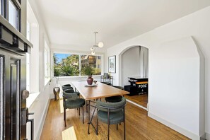 Eine moderne Küche mit einem Holztisch, Stühlen und Blick ins Freie.