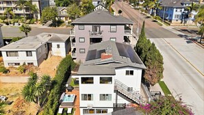 A residential building with a sloped roof, a visible garage, and a front yard with a swimming pool. - Family Oasis! Hot Tub Fire Pit Game Room Sleeps 12 (San Diego)