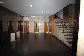 A lobby with a reception desk, multiple elevators, and a staircase. - PORTEÑO Central Apartment, GALERIAS PACIFICO (Buenos Aires)