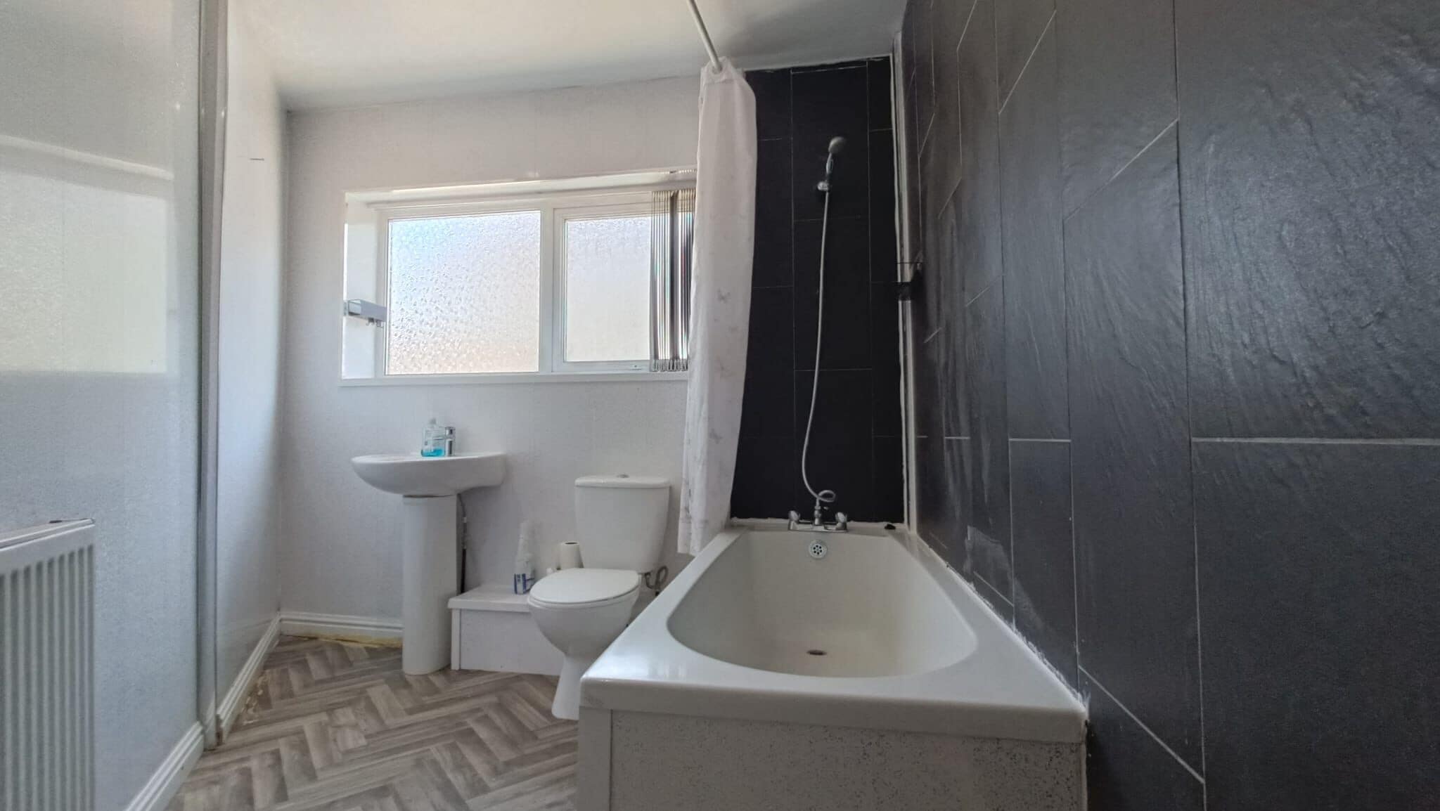 A bathroom with a bathtub, toilet, and sink.