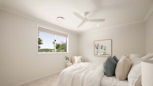 A bedroom with a bed, a ceiling fan, a window, and a framed picture on the wall. - Mooloolaba Family 5 Bedroom Haven (Sunshine Coast)