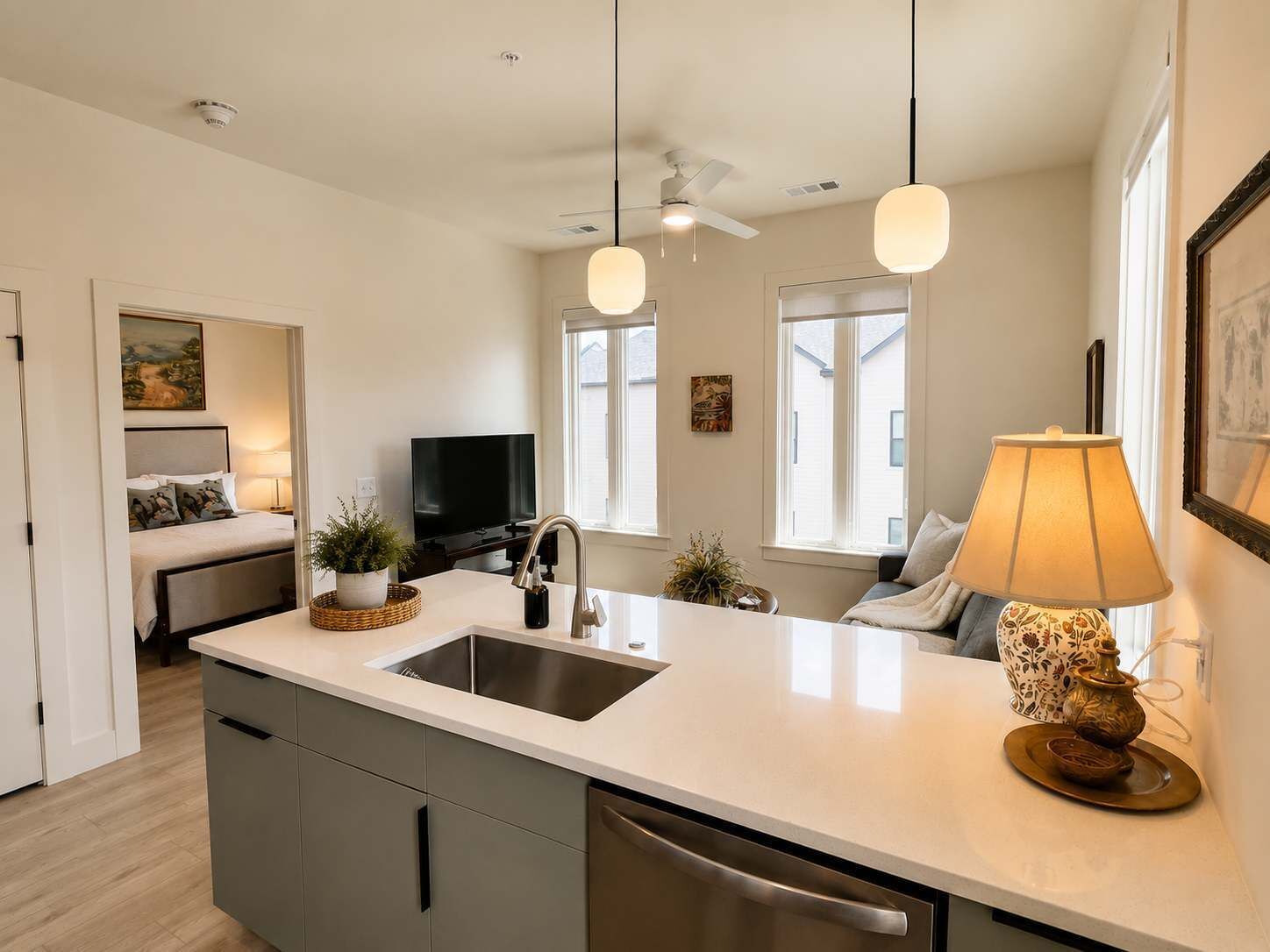 Une cuisine moderne dotée d’un îlot central, d’un lave-vaisselle encastré et de luminaires suspendus.
