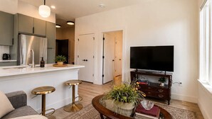Ein modernes Wohnzimmer mit Sofa, Couchtisch und Fernseher.