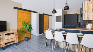 Een moderne keuken met een eethoek, houten kastjes en een potplant.