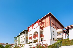 A multi-story hotel with balconies, a flat roof, and a clear blue sky. - Appartement Teilleria - Welkeys (Hendaye)