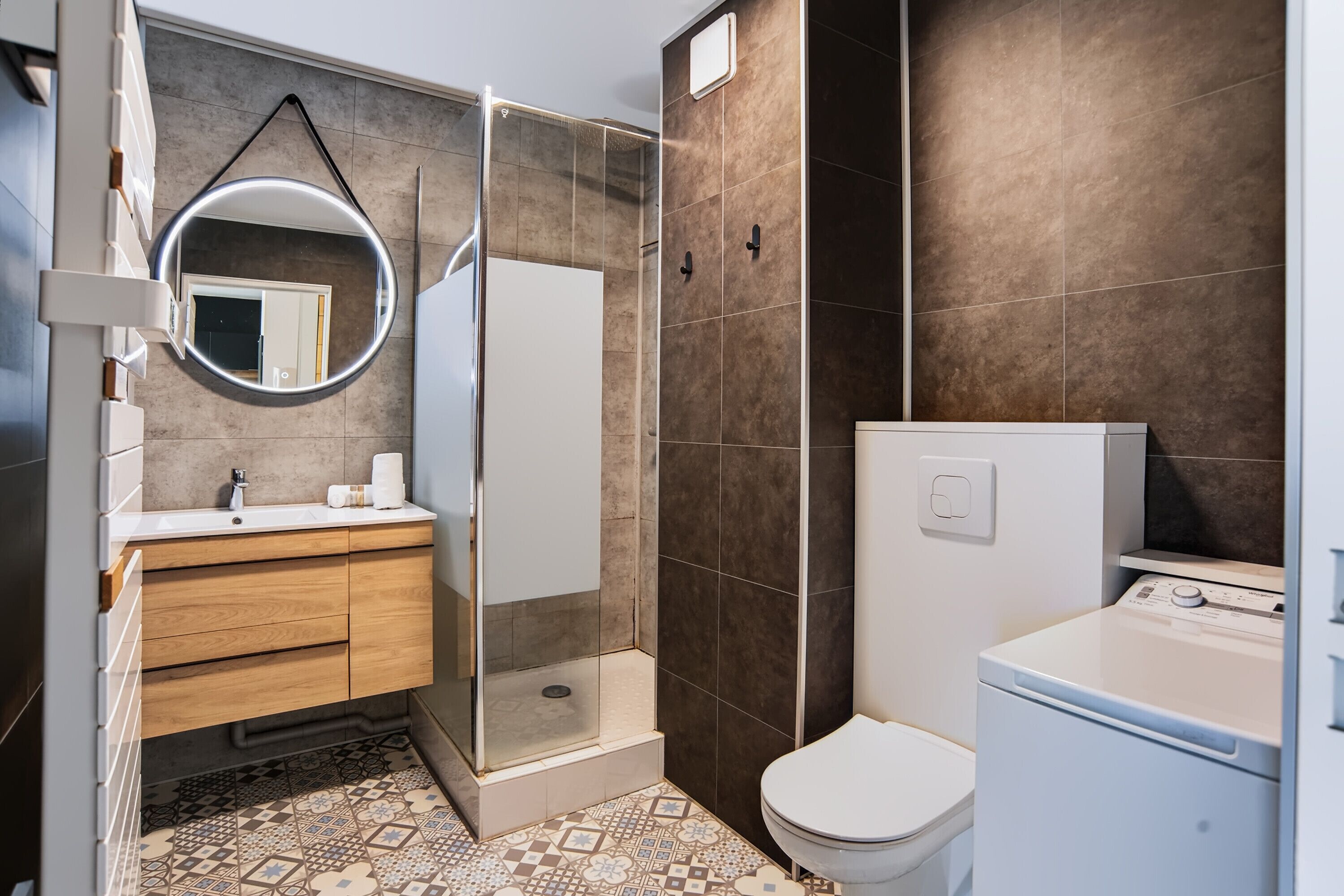 A modern bathroom with a shower, toilet, and sink.