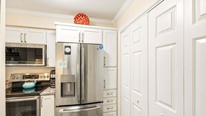 A kitchen with a stainless steel refrigerator, a microwave, an oven, and a water dispenser. - RSC203 - Wander Mint Soundfront condo with sunset views (Manteo)