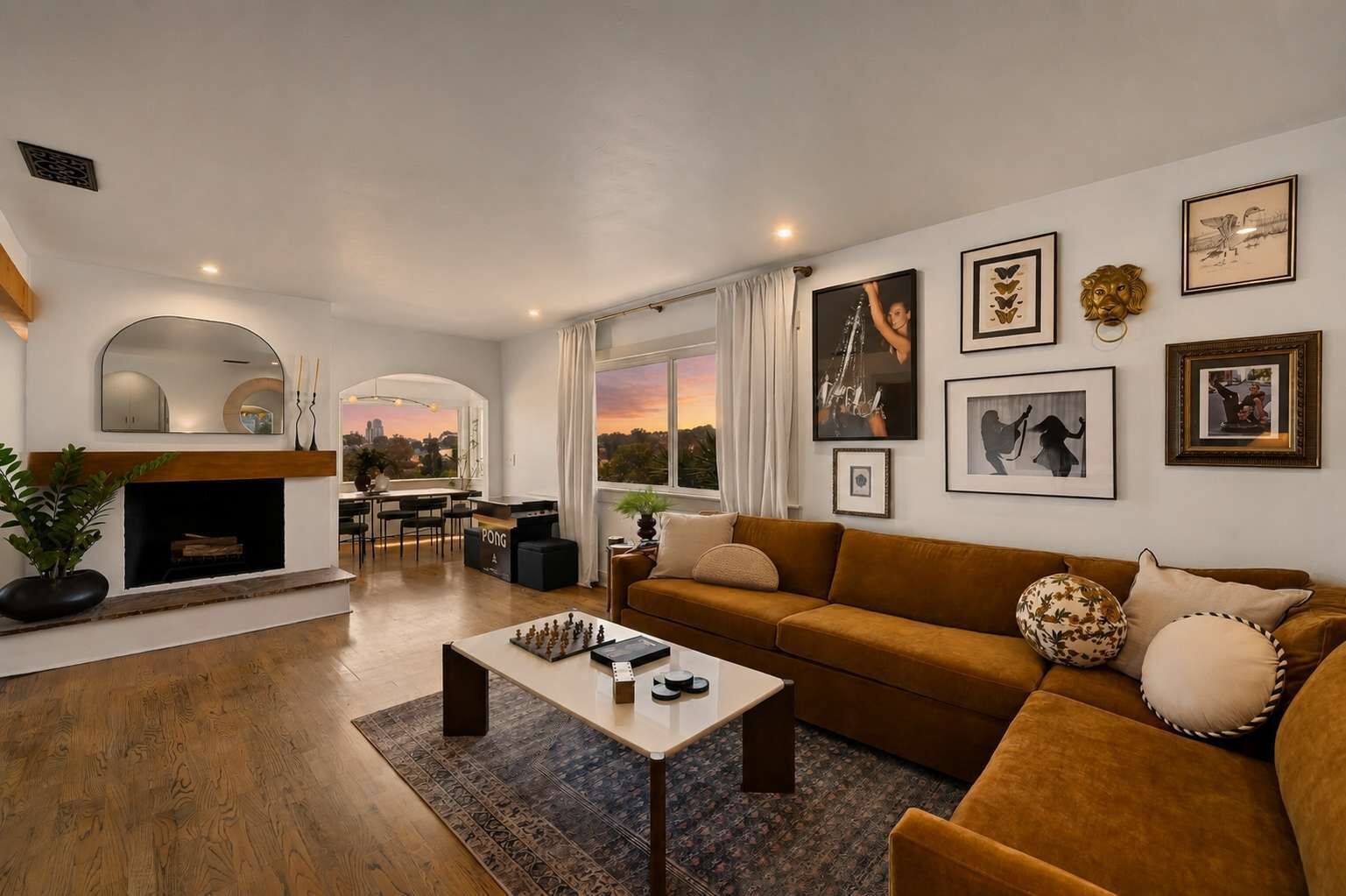 A modern living room with a fireplace, a sofa, a coffee table, and artwork on the walls.