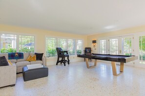 A spacious room with a pool table, a sofa, and a chair.