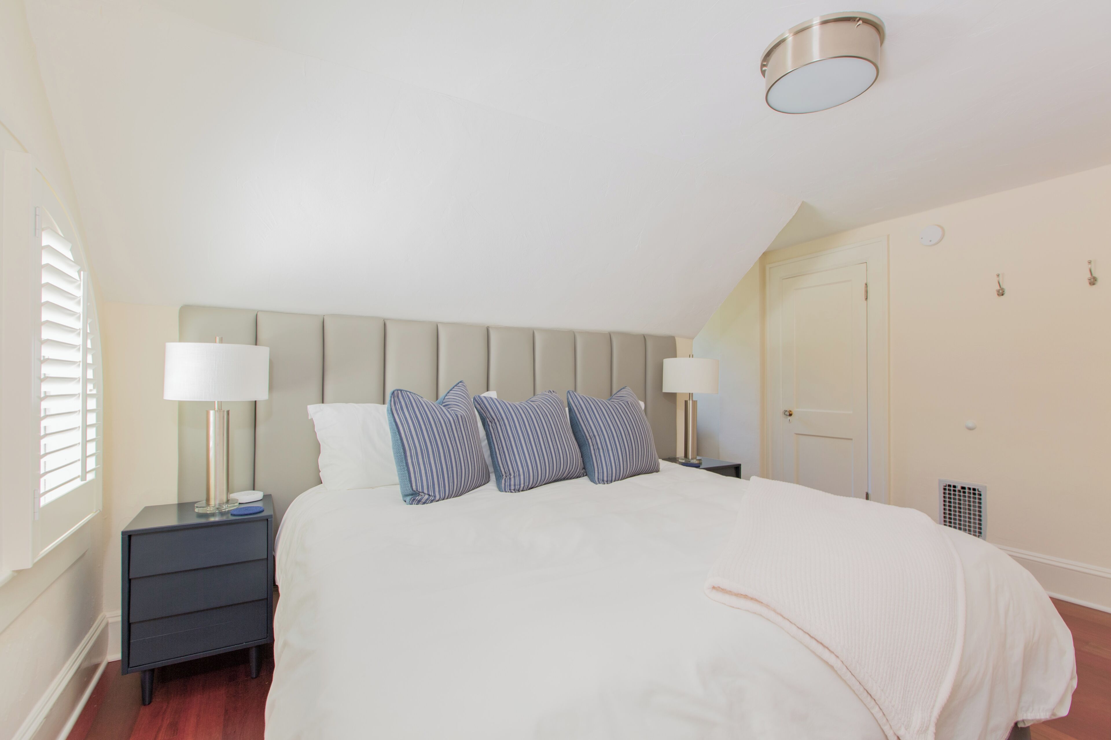 A neatly arranged bedroom with a bed, two bedside tables, and a headboard.