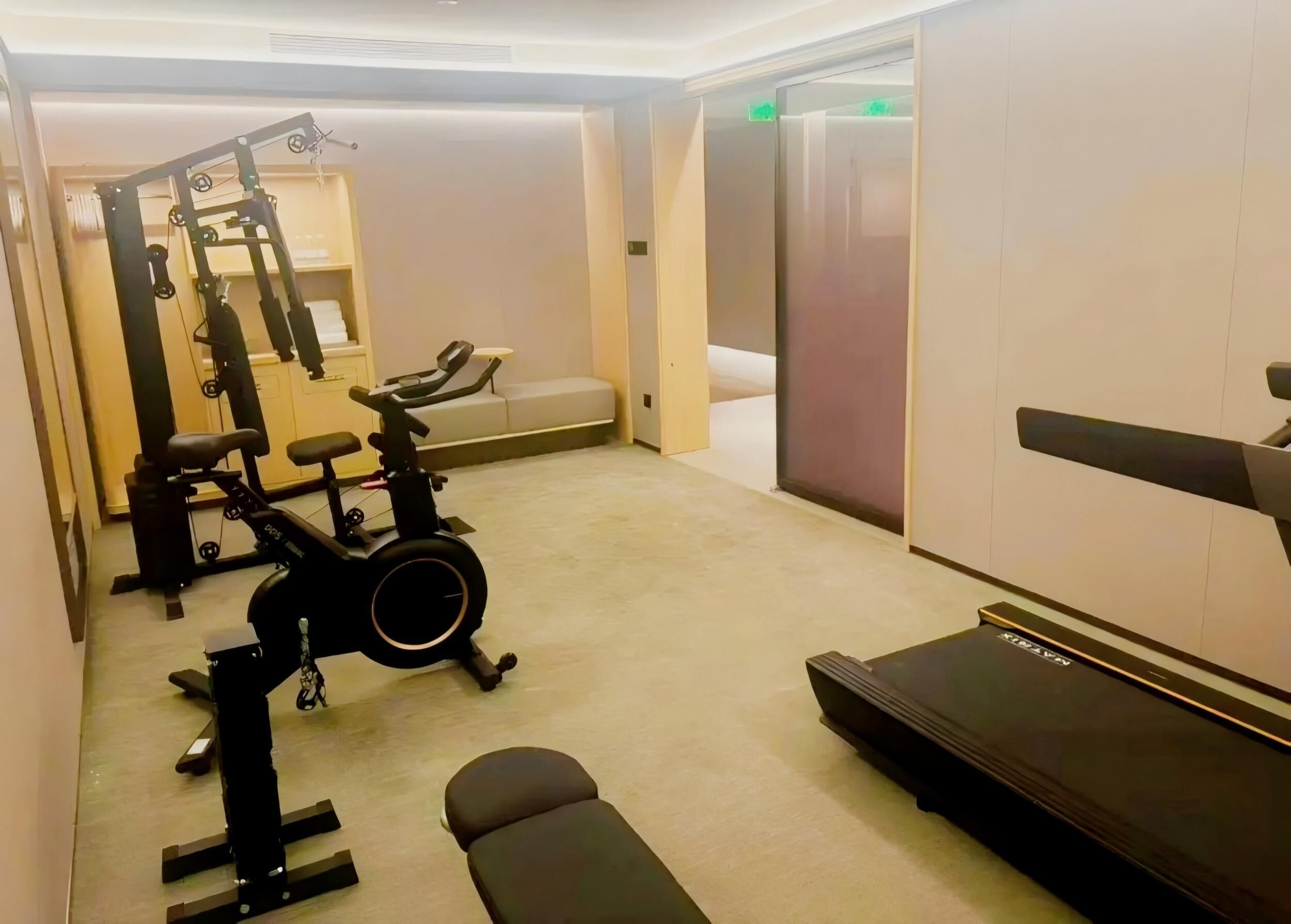 A gym with exercise equipment including a treadmill, stationary bike, and weights.