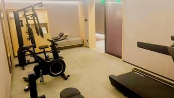 A gym with exercise equipment including a treadmill, stationary bike, and weights.