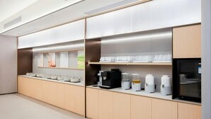 A modern kitchen with a long counter, various appliances, and a refrigerator. - JI HOTEL Wuhan Xudong Avenue (Wuhan)