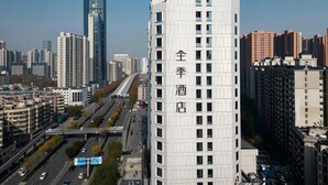 A high-rise building with a prominent vertical sign indicating a hotel. - JI HOTEL Wuhan Xudong Avenue (Wuhan)