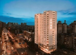 A high-rise hotel with multiple floors, a prominent entrance, and a view of the surrounding cityscape. - JI HOTEL Wuhan Xudong Avenue (Wuhan)