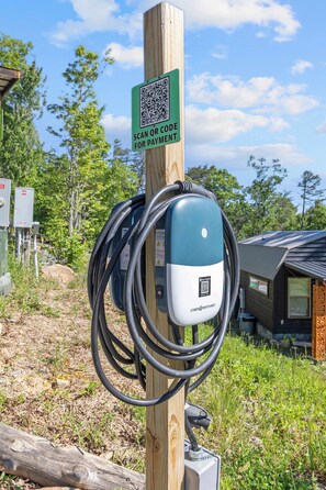 An electric vehicle charging station with a QR code for payment. - Meadowlark: Adventure Bunkhouse Near Downtown (Chattanooga)