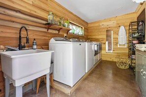 A compact kitchen with wooden walls, a sink, and two white appliances. - Meadowlark: Adventure Bunkhouse Near Downtown (Chattanooga)
