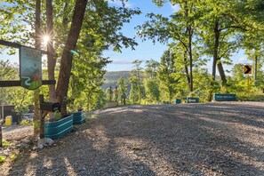 A gravel parking area with directional signs and a nature retreat sign. - Meadowlark: Adventure Bunkhouse Near Downtown (Chattanooga)