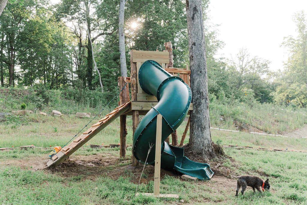 A playground with a slide and a wooden structure.