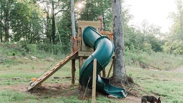 Une aire de jeux avec un toboggan et une structure en bois.