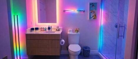 Un baño con inodoro, lavabo y zona de ducha.