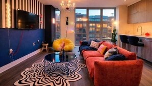 A modern living room with a sofa, a coffee table, and a TV mounted on the wall.