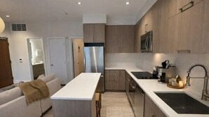 Uma cozinha moderna com uma ilha central, forno embutido e pia.