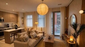 Uma sala de estar moderna com sofá, mesa de centro e área de jantar.