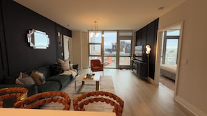En moderne stue med sofa, lænestole, sofabord og et TV-møbel.