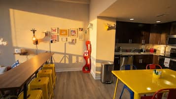 Una cocina moderna con armarios oscuros, un lavavajillas de acero inoxidable y un microondas.
