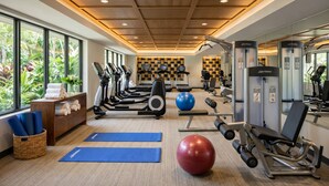 Un gimnasio con cintas de correr, balones de ejercicio y máquinas de pesas.