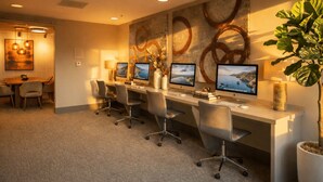 Een vergaderzaal met een lange tafel, vier stoelen en drie bureaureecomputers.