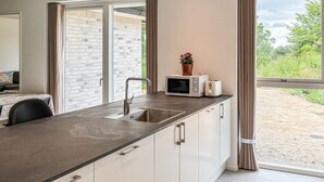 A modern kitchen with a built-in sink, a microwave, and a toaster on the counter. - Gorgeous home in Gilleleje with sauna (Gilleleje)