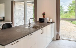 Eine moderne Küche mit integriertem Spülbecken, einer Mikrowelle und einem Toaster auf der Arbeitsfläche.